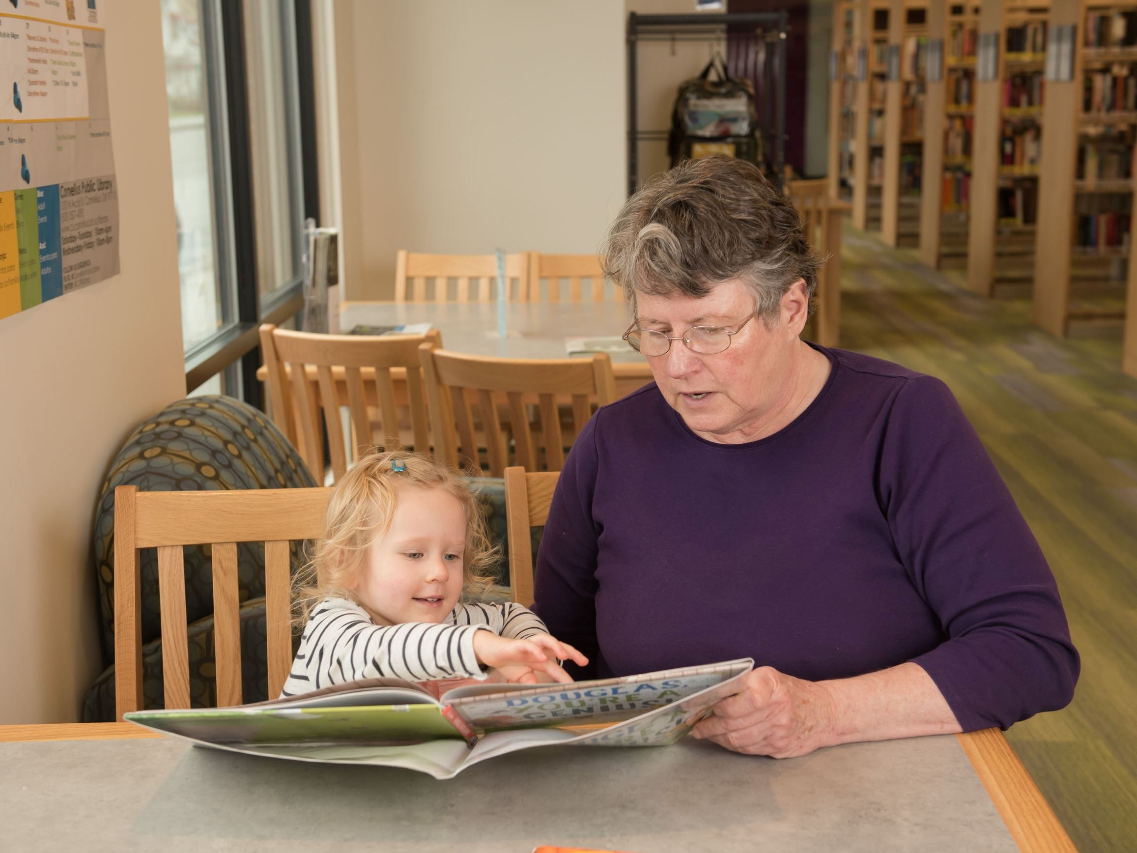 An adult reading to a child at the Cornelius Public Library