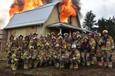 Large Group Posing in front of Burning Building